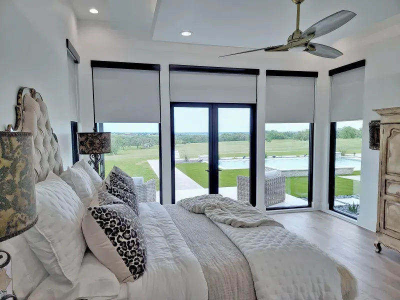 Bedroom with roller shades and a view